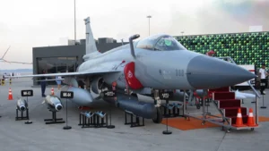 A Pakistan Air Force JF-17 Thunder Block III fighter jet on display on the apron with bombs and pods in front of it
