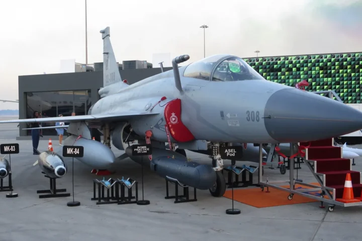 A Pakistan Air Force JF-17 Thunder Block III fighter jet on display on the apron with bombs and pods in front of it