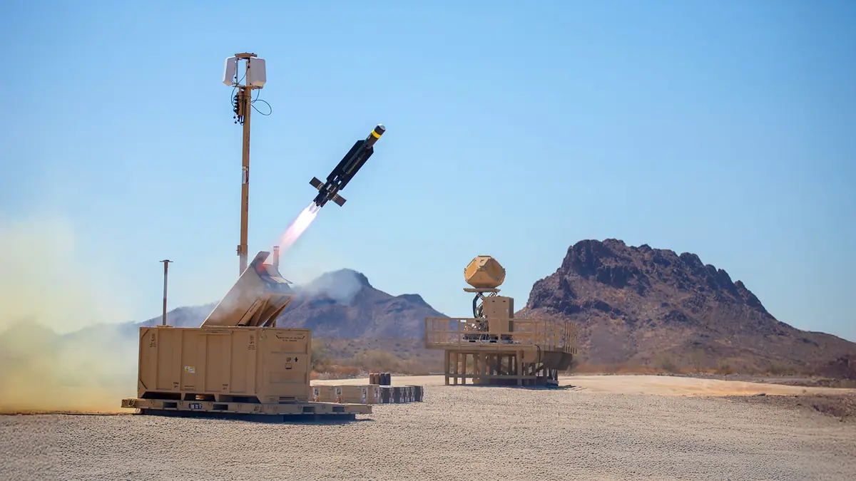 A Coyote interceptor launches from a desert test site beside a KuRFS radar