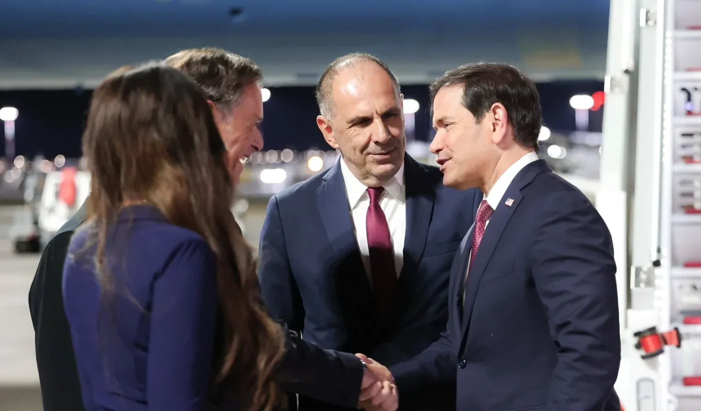 US Secretary of State Marco Rubio shaking hands with Greek Foreign Minister Giorgos Gerapetritis beside the aircraft steps at Athens airport at night