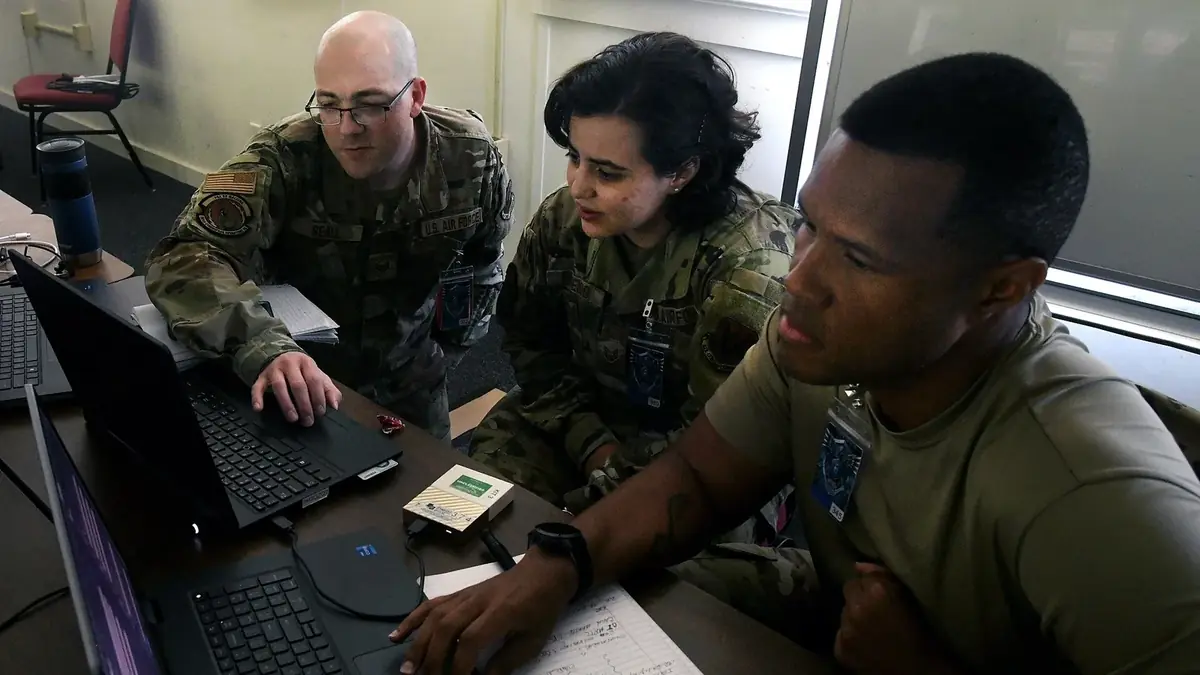 Cyber operations specialists examining network code at the Cyber Shield exercise