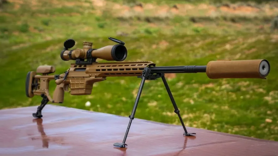 The SAKO TRG M10 rifle with scope, bipod and suppressor on a table