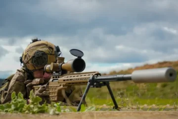 A Hellenic Army Special Forces sniper aiming a SAKO TRG M10 rifle with a suppressor