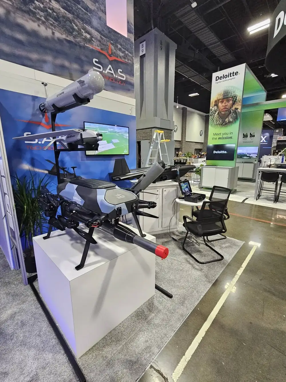The SARISA multicopter with a rocket launcher and, above it, the SeaSting and MFK-120X Midros models at the SAS Technology booth