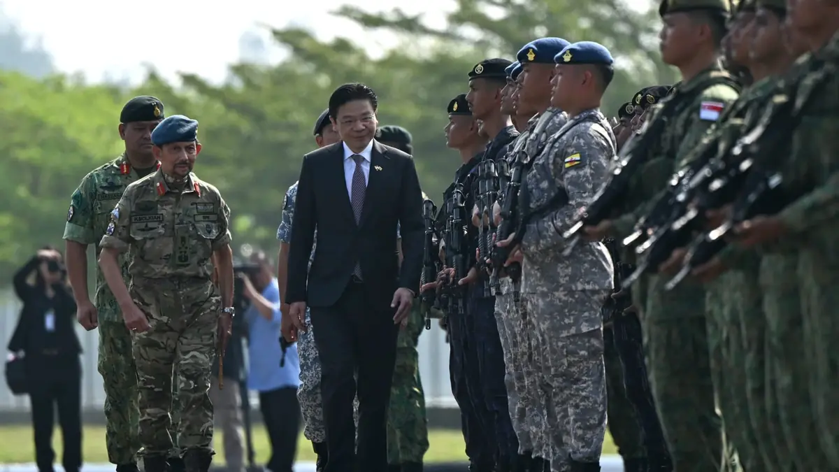 Singapore Prime Minister Lawrence Wong inspects a guard of Singaporean and Bruneian troops at the Joint Parade