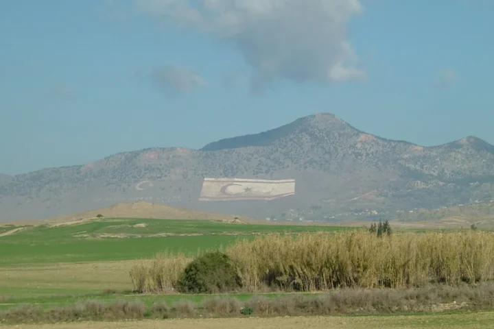 Giant flags of Turkey and the breakaway regime formed on the slope of the Pentadaktylos mountains in the occupied north of Cyprus, behind a plain
