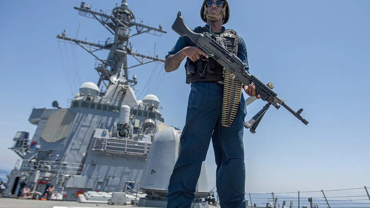 A sailor with a machine gun aboard the destroyer USS Paul Hamilton transiting the Strait of Hormuz