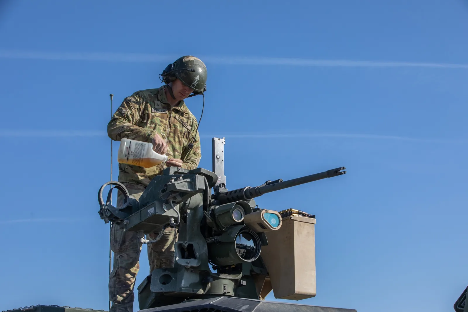 A US soldier maintains the remote weapon station with an M2 .50-calibre machine gun on top of a Stryker