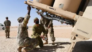 Soldiers in desert camouflage inspect a THAAD missile launcher in the Saudi desert
