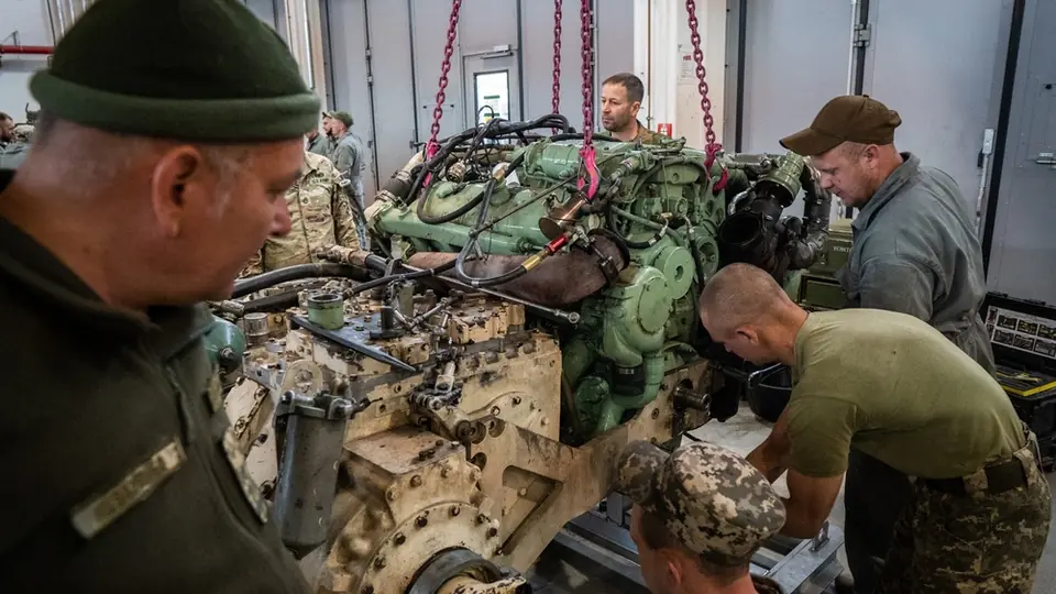 Ukrainian soldiers work on a vehicle engine during a training course in Germany