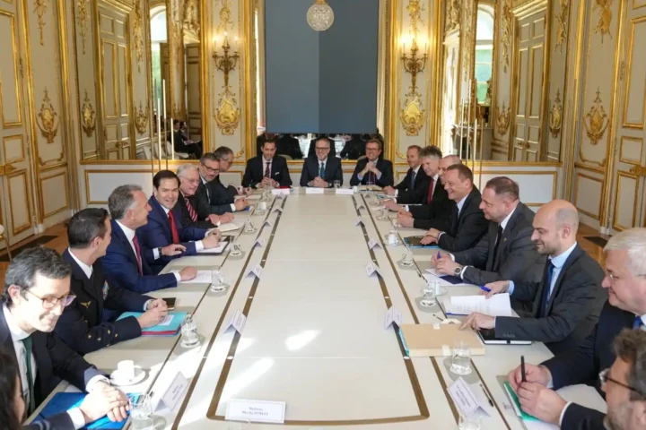 Delegations seated on both sides of a long table in a gilded room of the Élysée Palace during a meeting on Ukraine