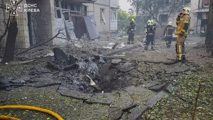Rescuers beside a crater and a damaged building in Kyiv after a Russian drone strike on 9 September 2026