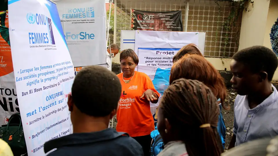 A UN Women representative speaks to a group of people at an exhibition on women, peace and security in Goma