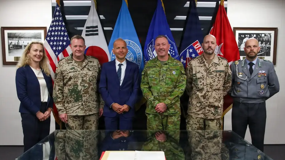 German defence ministry and embassy officials pose with the deputy commander of United Nations Command in the Armistice Room at the command's headquarters in South Korea