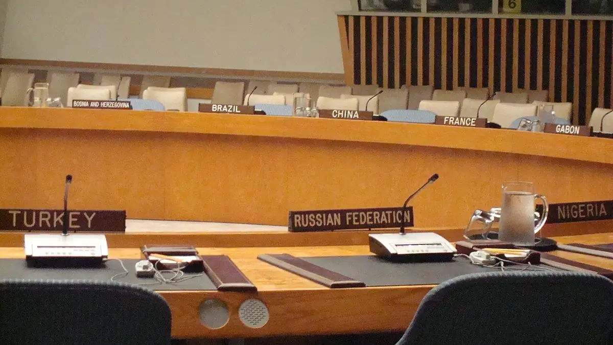 Delegation nameplates and microphones at the table of the UN Security Council chamber in New York