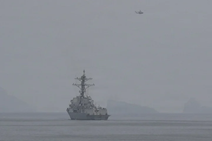 U.S. Navy destroyer and helicopter in haze during an April 2026 Hormuz mine-clearance mission