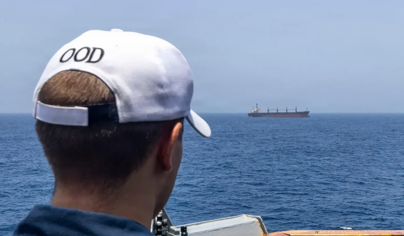 US Navy sailor aboard USS Michael Murphy observes a merchant vessel during June 2026 blockade operations, archive photograph