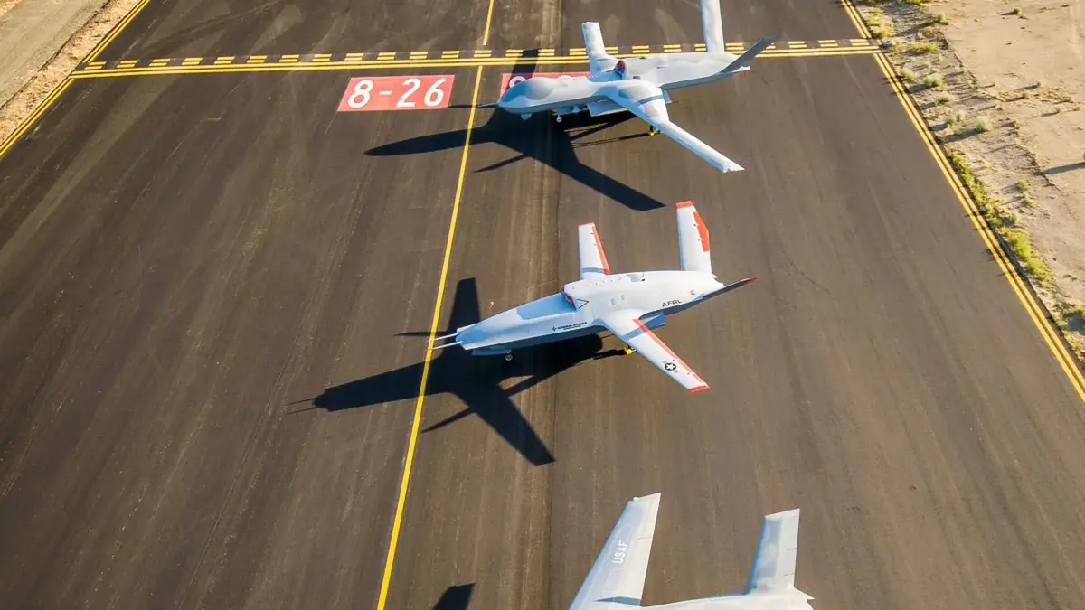 The XQ-67A flying with an MQ-20 Avenger and a third aircraft over the California desert