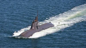 A German Type 212A submarine sailing on the surface, with its sail and rudder visible